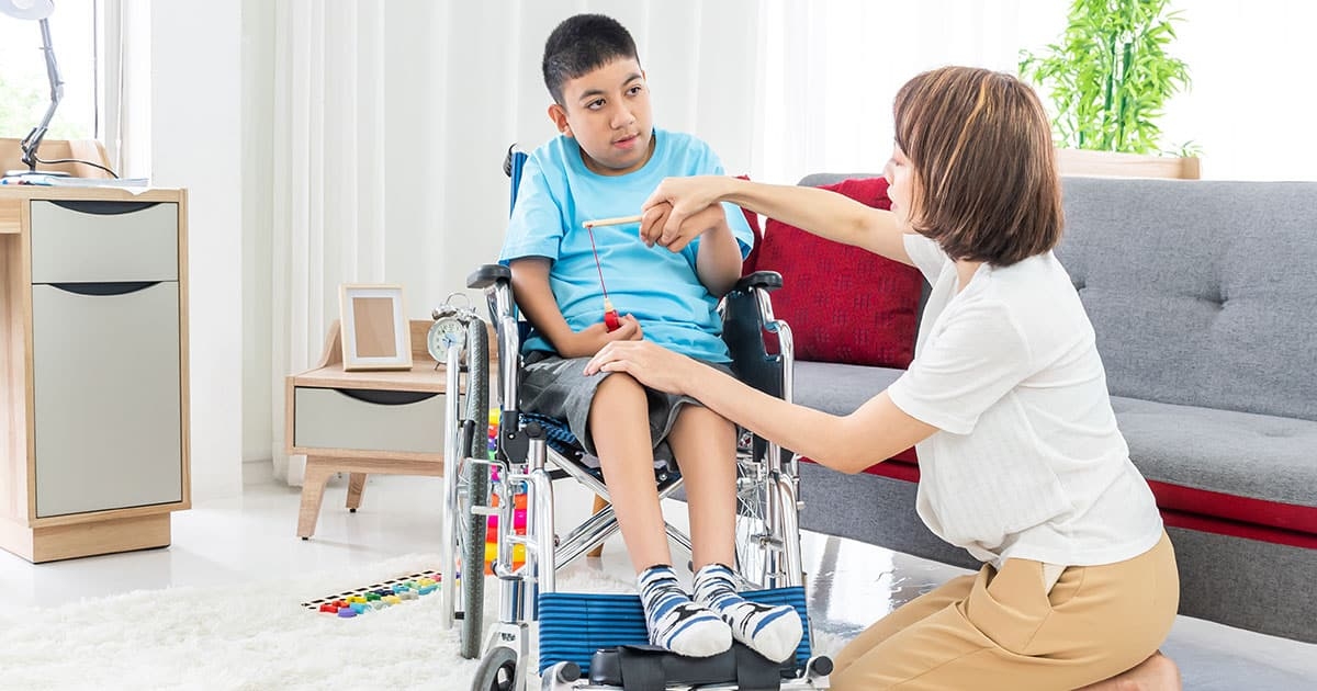 mother playing with son in wheelchair with syngap1-related epilepsy