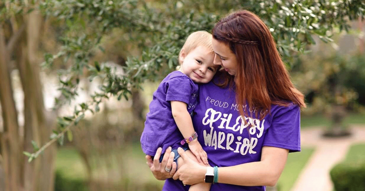 woman holding her child wearing purple epilepsy warrior shirts