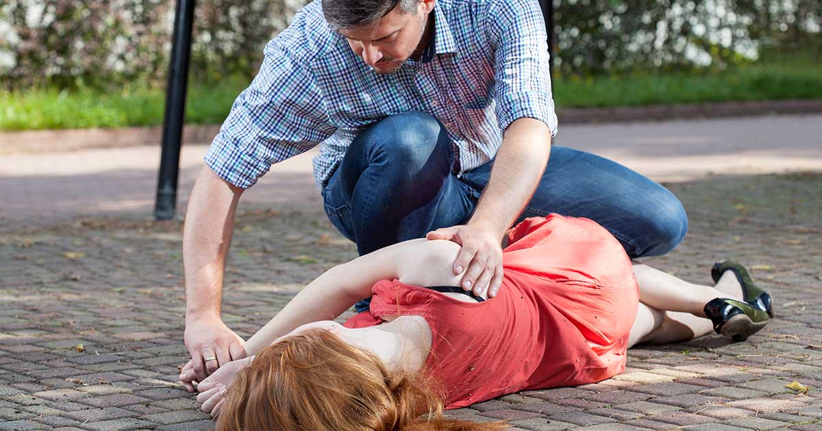 woman-lying-ground-man-first-aid